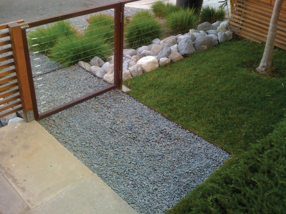 Inspiration for a mid-sized modern front yard partial sun xeriscape for spring in Los Angeles with gravel.