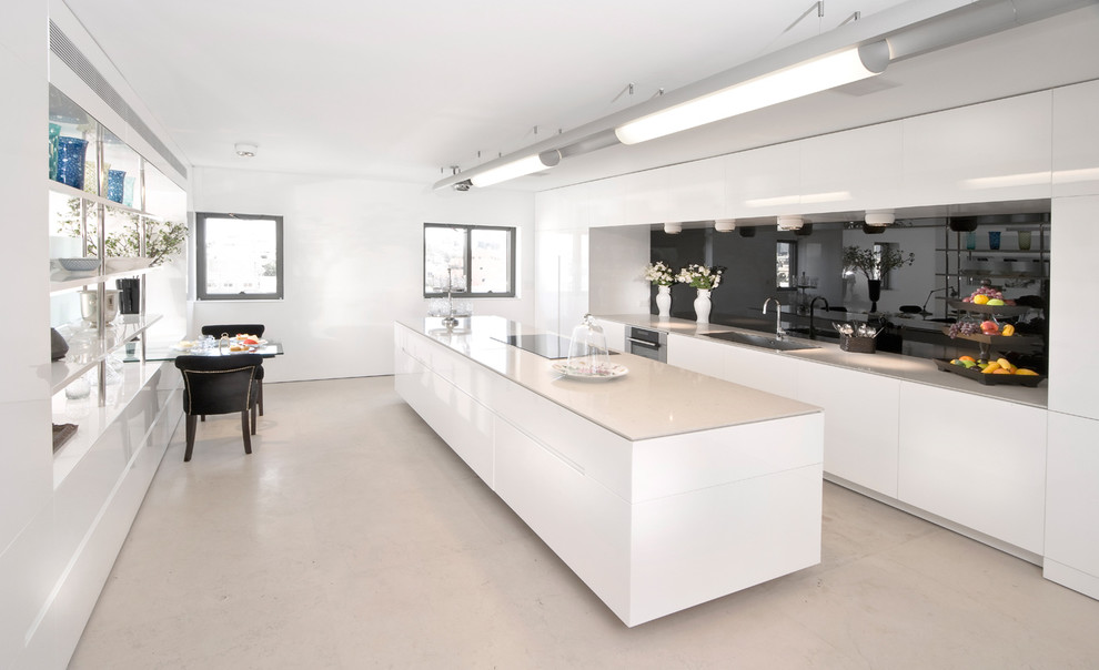 Photo of a modern galley kitchen in Other with flat-panel cabinets, white cabinets, black splashback, glass sheet splashback and panelled appliances.