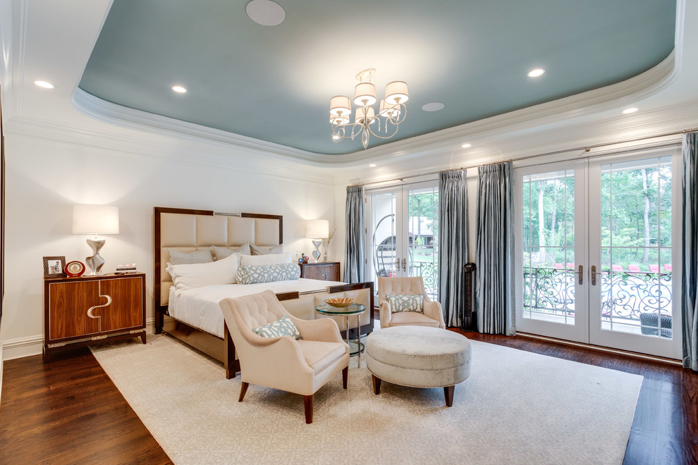 This is an example of a transitional master bedroom in DC Metro with white walls, dark hardwood floors, brown floor, a standard fireplace and a wood fireplace surround.