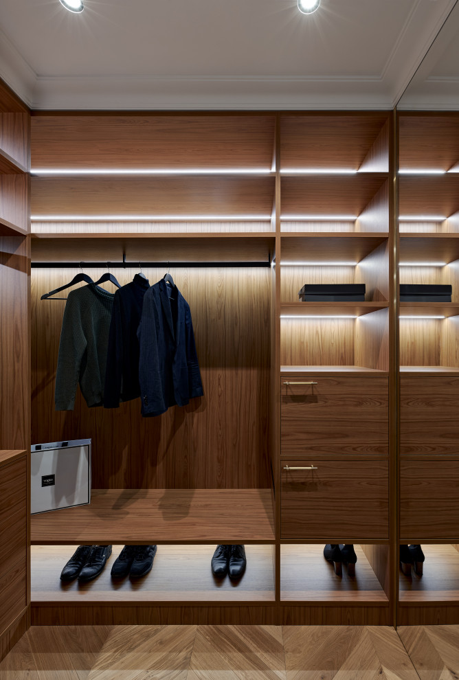 Стильный дизайн: встроенный шкаф среднего размера в современном стиле с паркетным полом среднего тона и коричневым полом - последний тренд