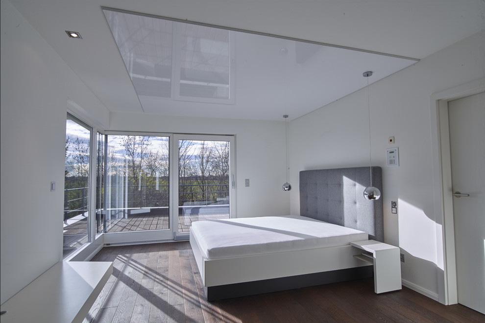 Hauptschlafzimmer With weißer Wandfarbe, dunklem Holzboden and braunem Boden in Munich