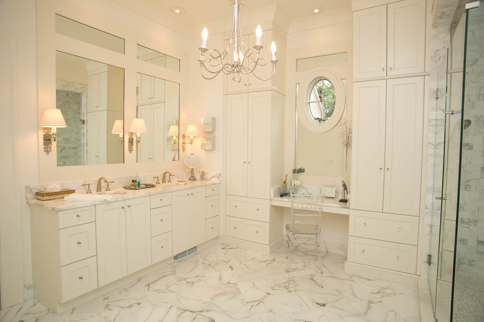 Inspiration for a large transitional master bathroom in New Orleans with an undermount sink, recessed-panel cabinets, white cabinets, marble benchtops, a freestanding tub, stone tile, white walls, marble floors and white tile.