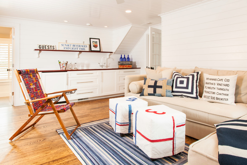 This is an example of a beach style family room in Boston with white walls and medium hardwood floors.