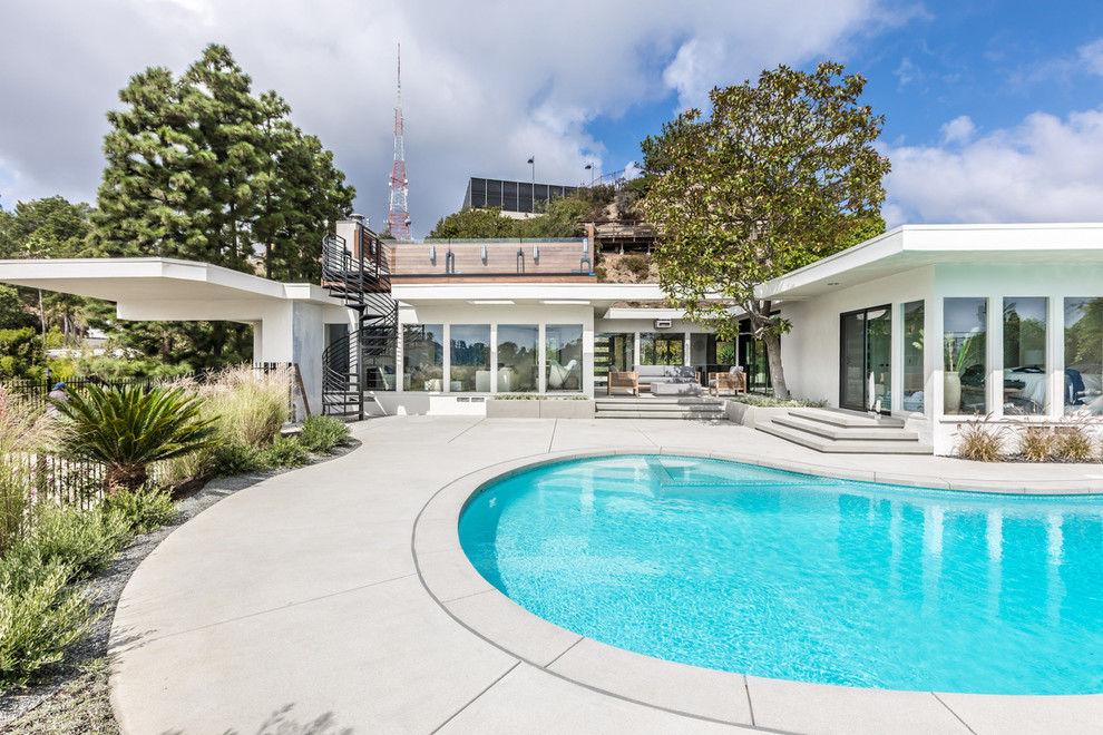Photo of a midcentury one-storey stucco white house exterior in Los Angeles with a flat roof.