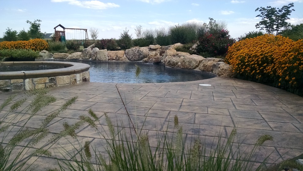 Hot tub - large rustic backyard custom-shaped and stamped concrete natural hot tub idea in New York
