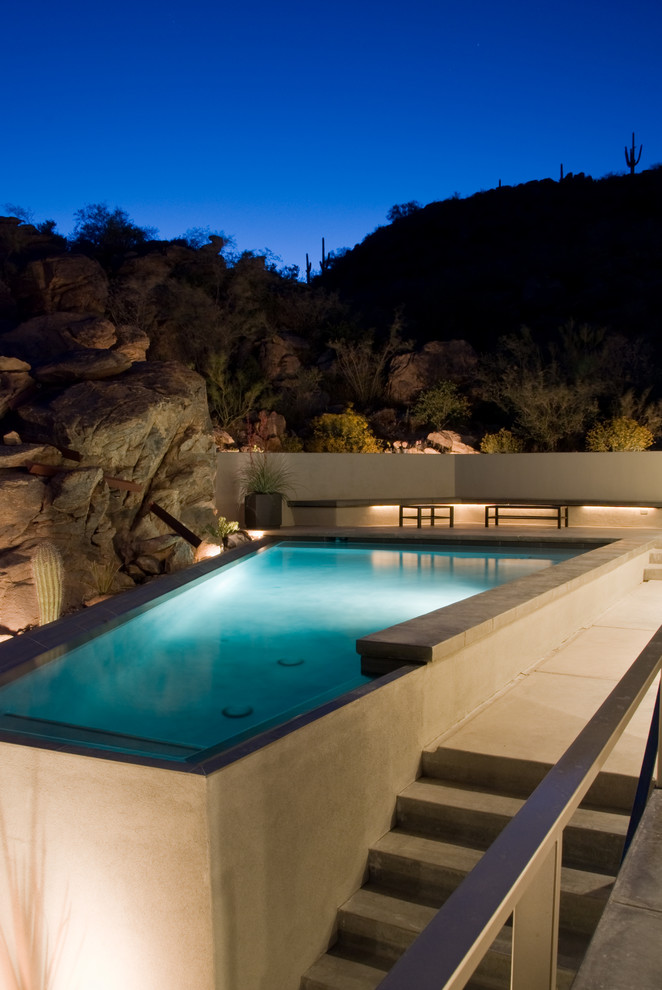 This is an example of a contemporary custom-shaped pool in Phoenix with a hot tub.