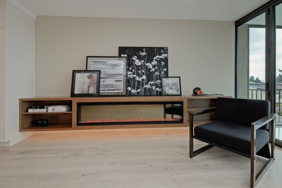 Mittelgroßes, Offenes Modernes Wohnzimmer mit beiger Wandfarbe, braunem Holzboden, Gaskamin, Kaminumrandung aus Holz und beigem Boden in Vancouver