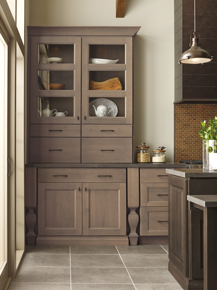 Example of a brown floor eat-in kitchen design with dark wood cabinets, stainless steel appliances, an island and brown countertops