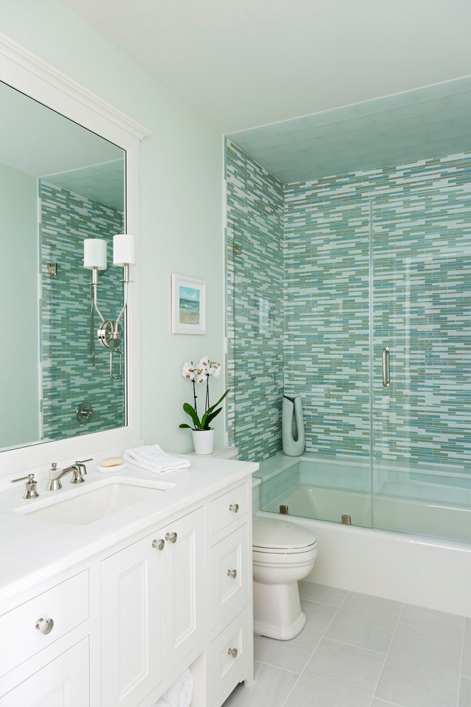 Inspiration for a beach style 3/4 bathroom in Charleston with recessed-panel cabinets, white cabinets, an alcove tub, green tile, matchstick tile, green walls, an undermount sink, grey floor and white benchtops.