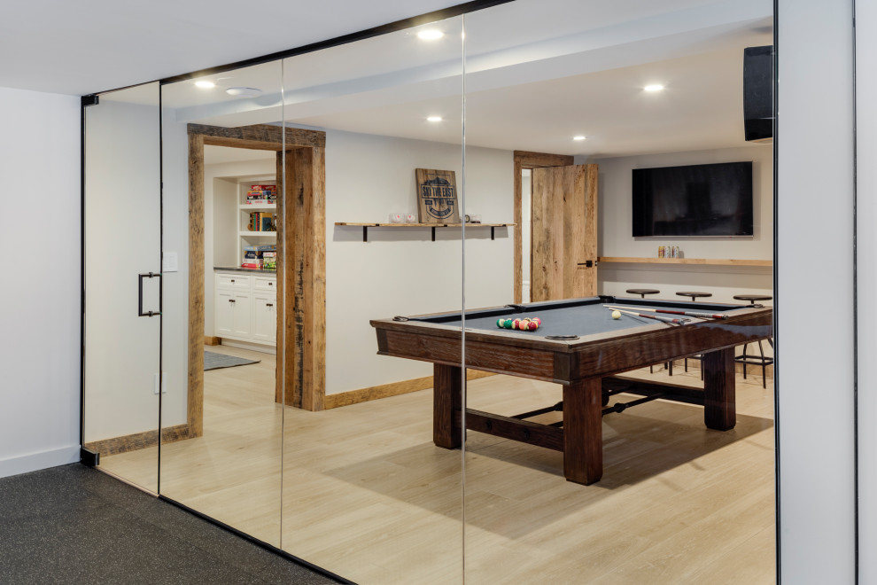 Example of a mid-sized mountain style walk-out light wood floor basement design in Boston with white walls