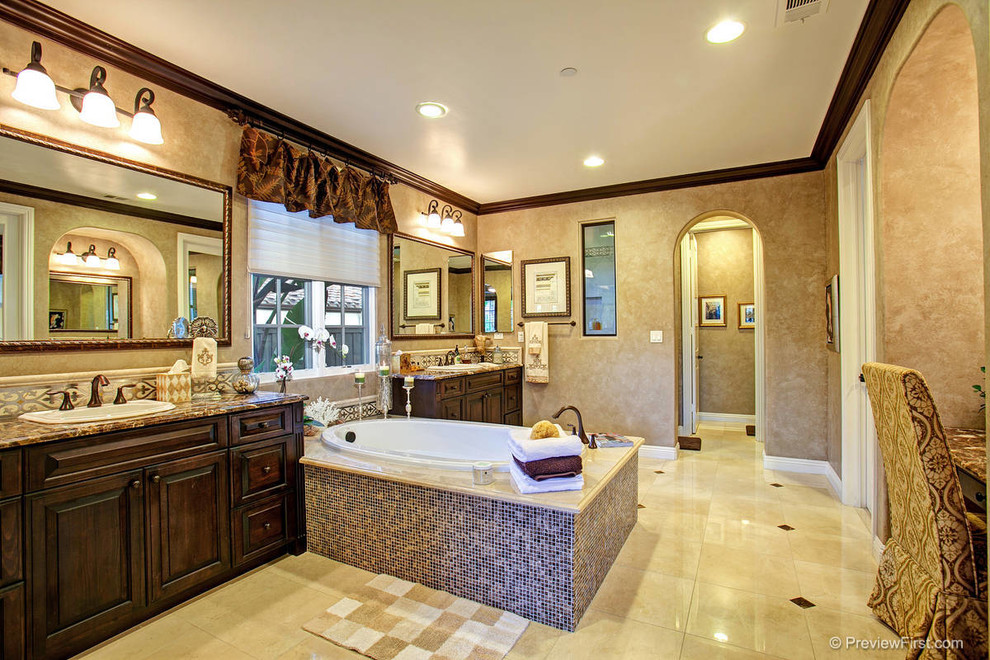 Inspiration for an expansive mediterranean master bathroom in San Diego with dark wood cabinets, granite benchtops, multi-coloured tile, beige walls and travertine floors.