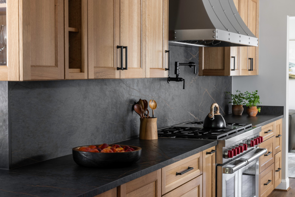 Inspiration for a large rustic galley medium tone wood floor enclosed kitchen remodel in DC Metro with recessed-panel cabinets, medium tone wood cabinets, quartz countertops, black backsplash, quartz backsplash, stainless steel appliances, no island and black countertops