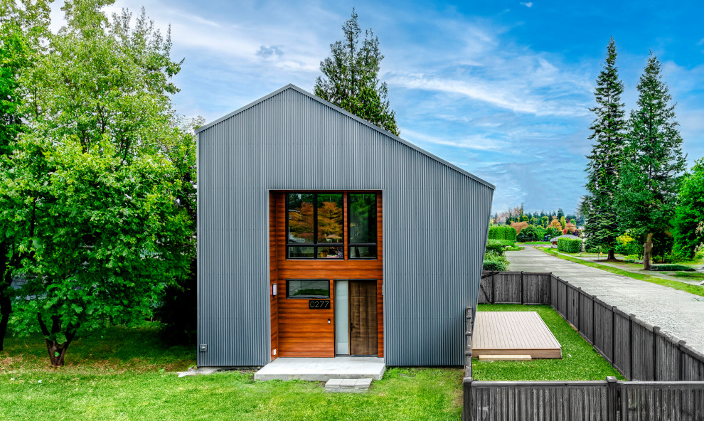 Mittelgroßes Einfamilienhaus mit Metallfassade, weißer Fassadenfarbe und Blechdach in Seattle