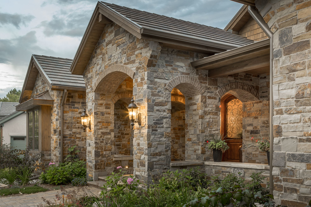Photo of a traditional one-storey house exterior in Denver with stone veneer and a gable roof.