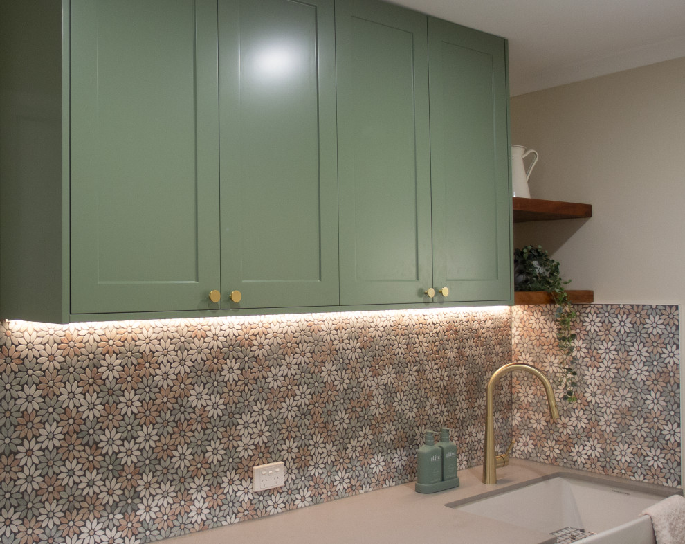 Design ideas for a small contemporary single-wall laundry room in Gold Coast - Tweed with a farmhouse sink, shaker cabinets, green cabinets, concrete benchtops, mosaic tile splashback, beige walls, dark hardwood floors, a side-by-side washer and dryer, brown floor and grey benchtop.