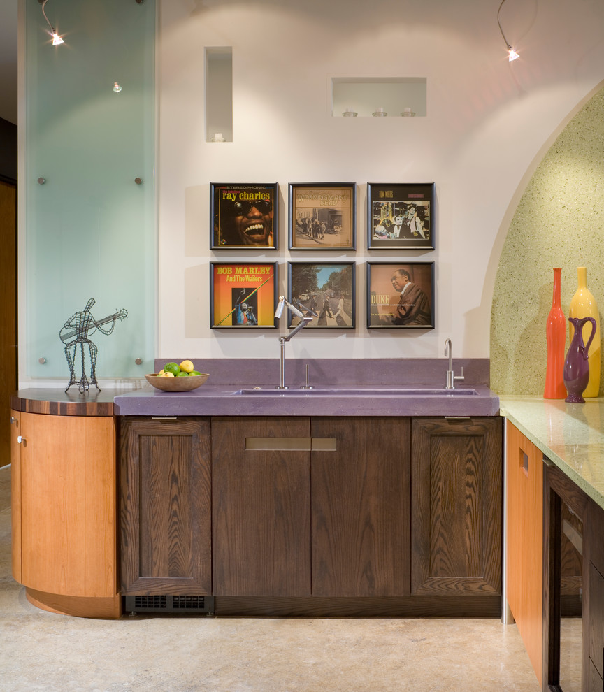 Inspiration for a small contemporary l-shaped wet bar in Kansas City with an integrated sink, flat-panel cabinets, medium wood cabinets, recycled glass benchtops, multi-coloured splashback, glass sheet splashback, concrete floors and purple benchtop.