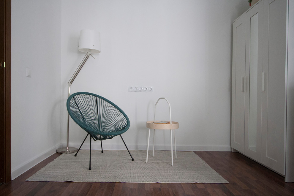 Foto di un piccolo soggiorno scandinavo con pareti bianche, pavimento in laminato e pavimento marrone