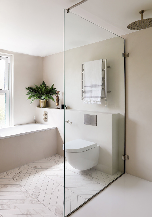 Inspiration for a modern family bathroom in London with a built-in bath, a walk-in shower, a wall mounted toilet, black and white tiles, beige walls, marble flooring, white floors, an open shower, double sinks, a built in vanity unit and a trough sink.