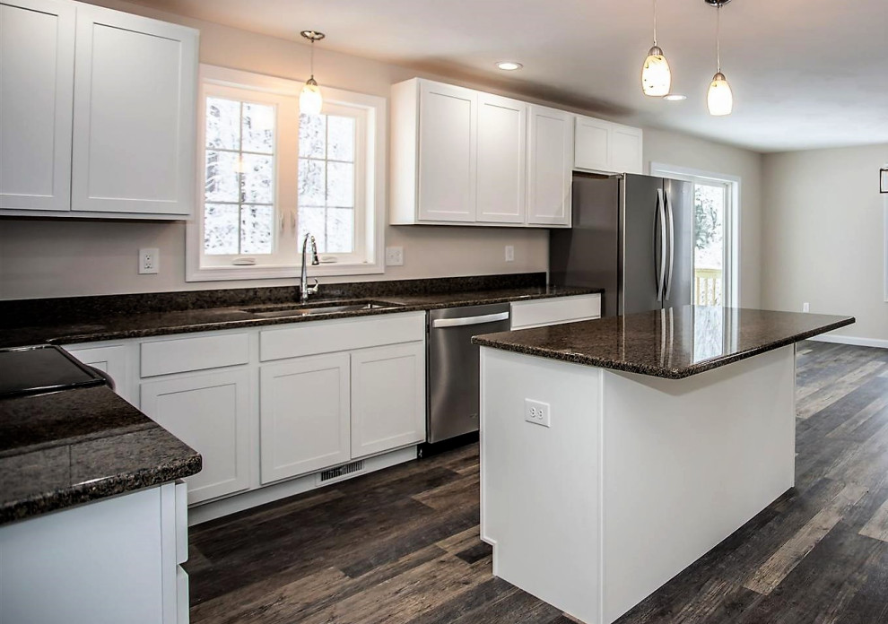 This is an example of a mid-sized transitional l-shaped eat-in kitchen in Boston with an undermount sink, shaker cabinets, white cabinets, granite benchtops, brown splashback, granite splashback, stainless steel appliances, with island and brown benchtop.