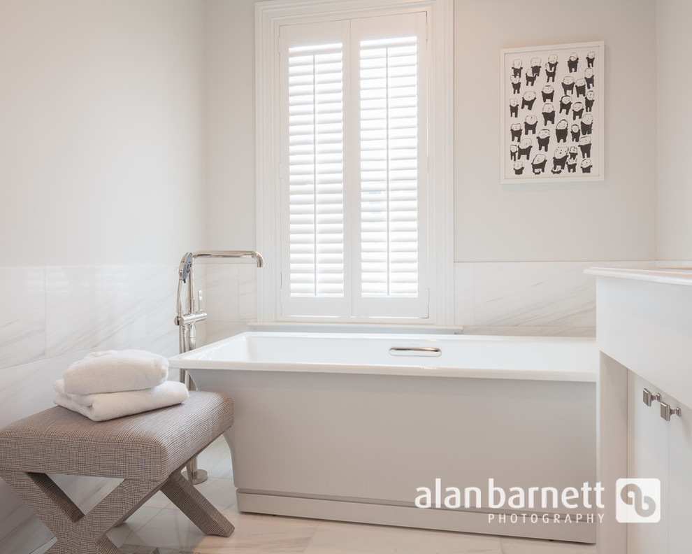 Example of a transitional master bathroom design in New York