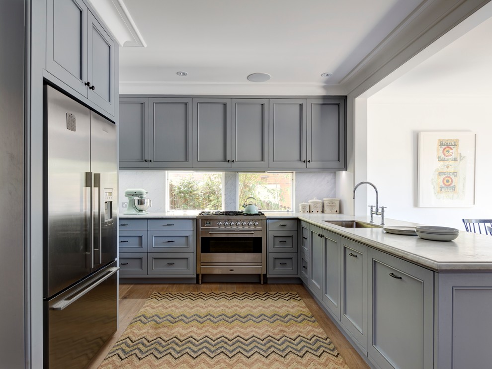Inspiration for a large transitional l-shaped eat-in kitchen in Sydney with an undermount sink, recessed-panel cabinets, grey cabinets, marble benchtops, grey splashback, stone slab splashback, stainless steel appliances, light hardwood floors and a peninsula.