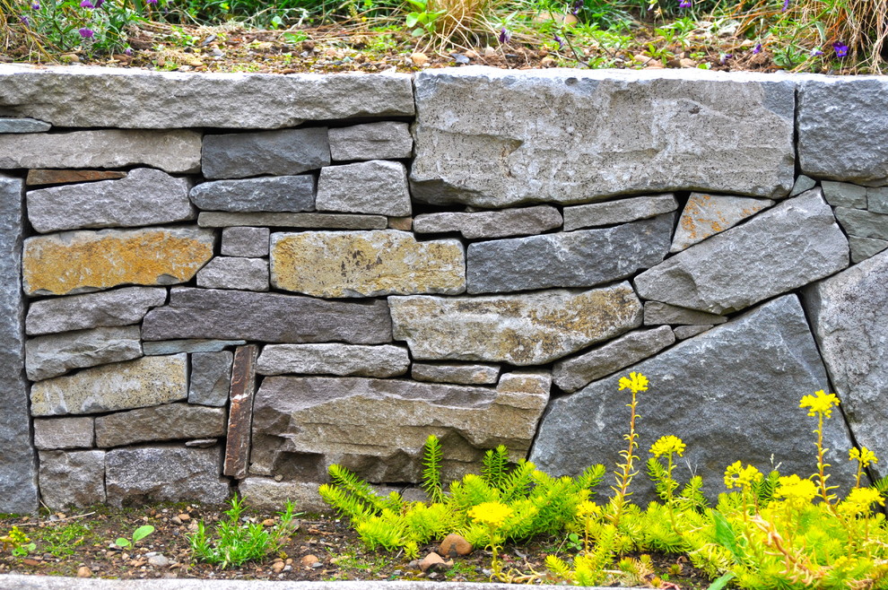 This is an example of a traditional sloped garden in Portland with a retaining wall.