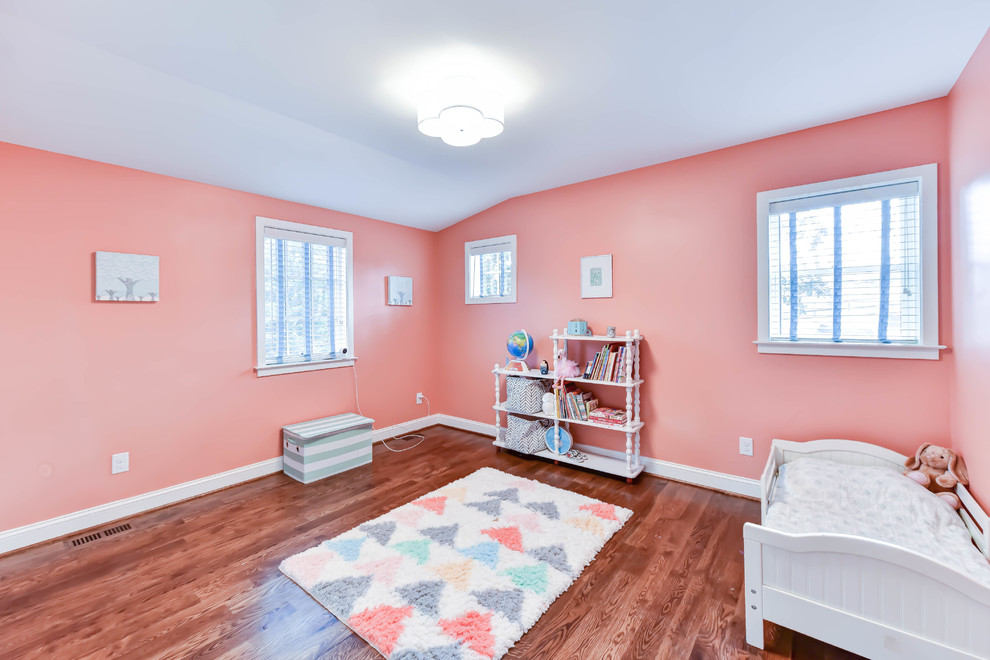 Inspiration for a mid-sized traditional kids' bedroom for kids 4-10 years old and girls with pink walls, medium hardwood floors and brown floor.