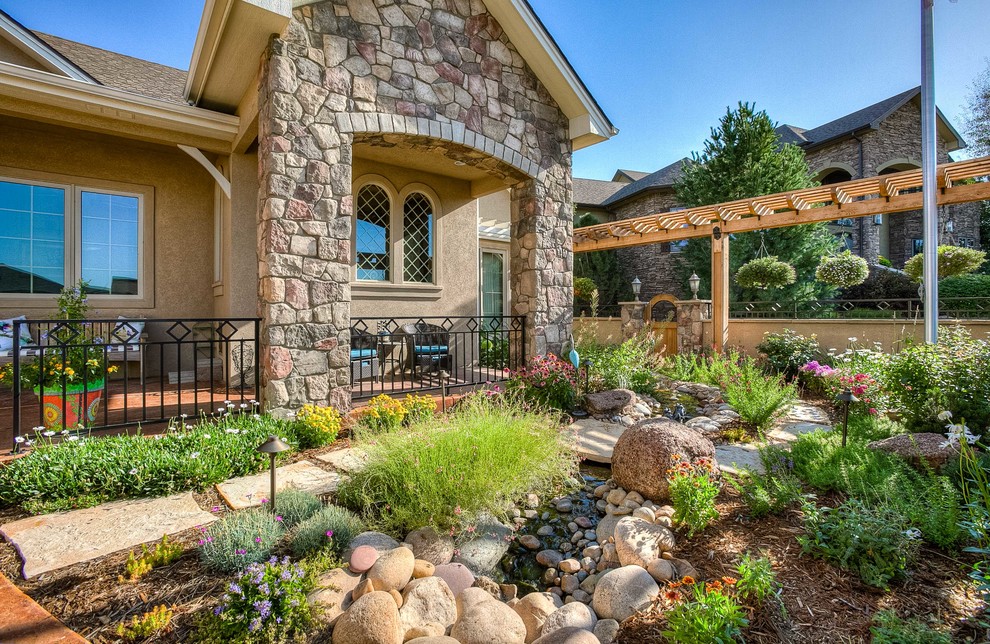 This is an example of a mid-sized transitional partial sun front yard stone walkway in Denver.