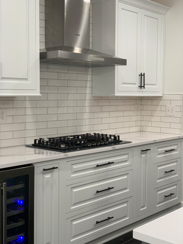 Eat-in kitchen - transitional marble floor and black floor eat-in kitchen idea with an undermount sink, quartz countertops, ceramic backsplash, stainless steel appliances, an island and white countertops