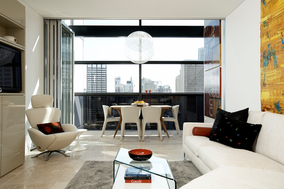 This is an example of a contemporary living room in Sydney with white walls, a wall-mounted tv and beige floor.