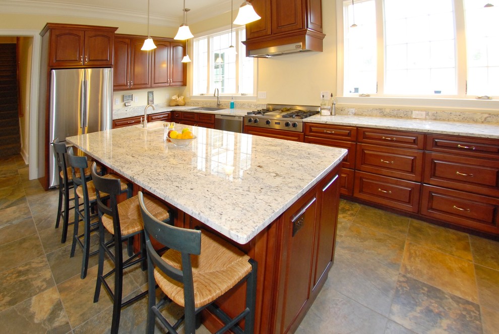 This is an example of a traditional l-shaped separate kitchen in Atlanta with an undermount sink, medium wood cabinets, quartzite benchtops, white splashback, stainless steel appliances, slate floors, with island and beige floor.