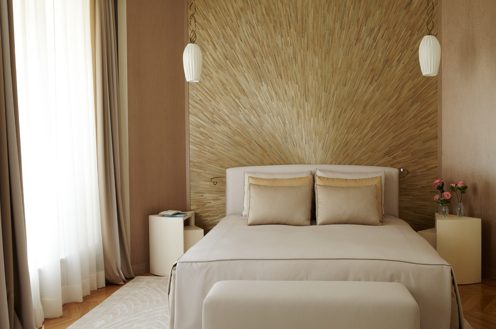 Photo of a contemporary bedroom in Paris with beige walls and light hardwood floors.