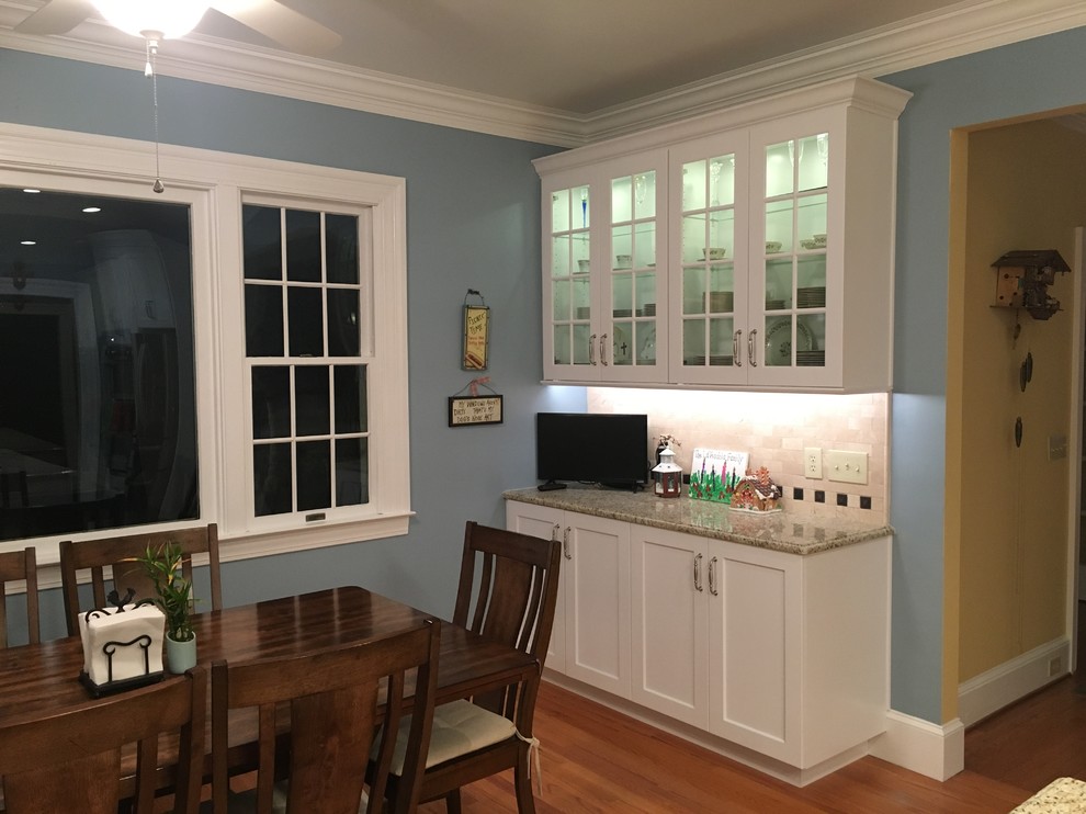 Inspiration for a large transitional l-shaped medium tone wood floor and brown floor eat-in kitchen remodel with an undermount sink, shaker cabinets, white cabinets, granite countertops, beige backsplash, subway tile backsplash, stainless steel appliances, an island and beige countertops