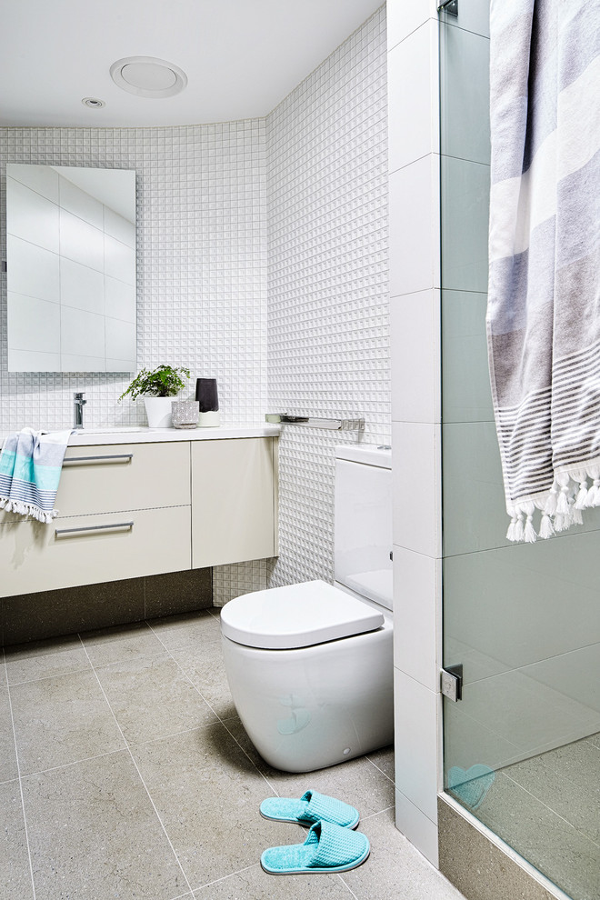 Photo of a small contemporary bathroom in Melbourne with beige cabinets, porcelain tile, white walls and solid surface benchtops.