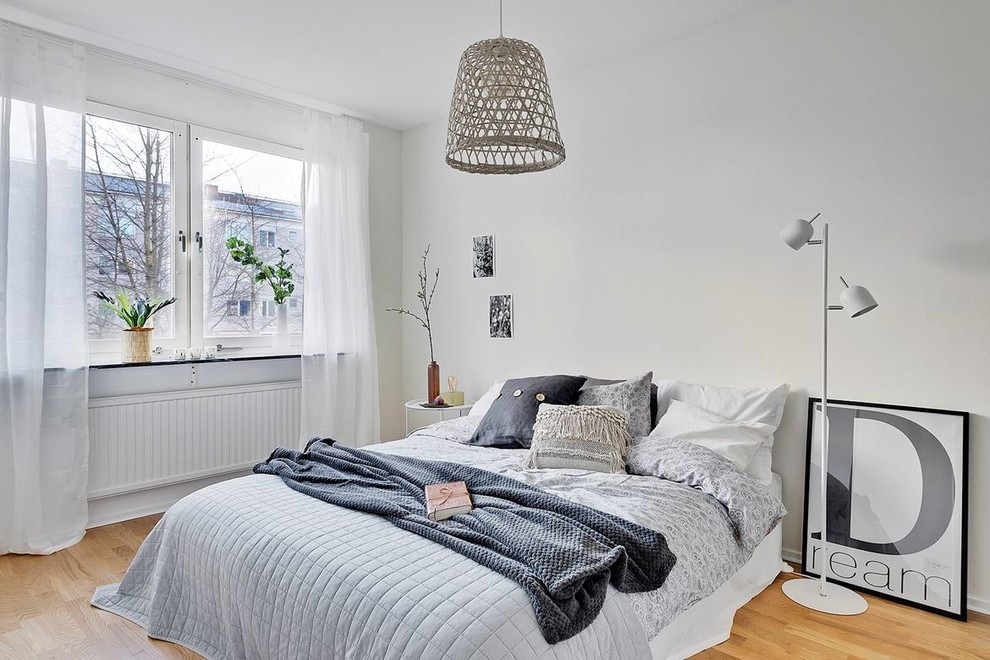 Inspiration for a scandinavian master bedroom in Stockholm with white walls and light hardwood floors.