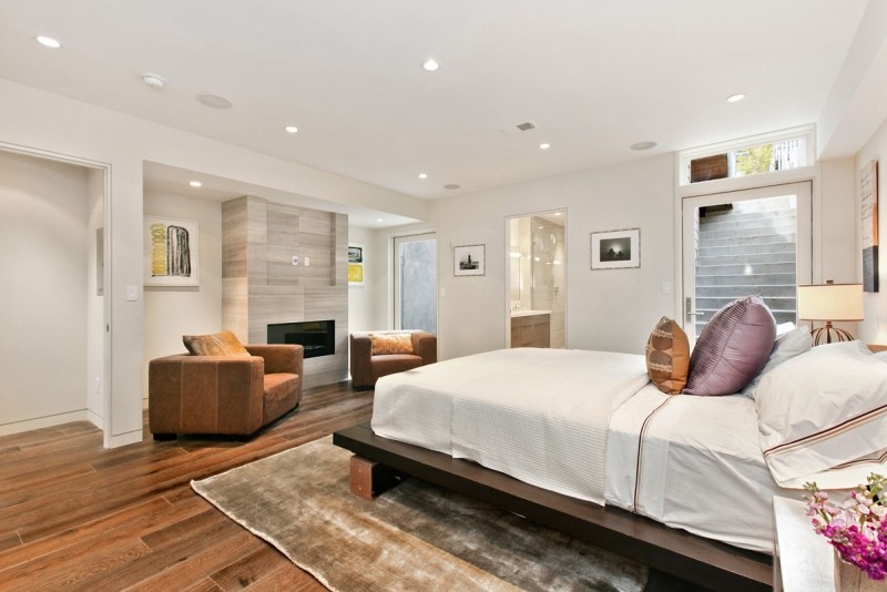 This is an example of a mid-sized contemporary master bedroom in San Francisco with white walls, porcelain floors, no fireplace and brown floor.