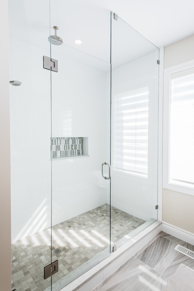 This is an example of a mid-sized transitional master bathroom in Toronto with shaker cabinets, dark wood cabinets, a drop-in tub, an alcove shower, white tile, subway tile, beige walls, ceramic floors, an undermount sink and solid surface benchtops.