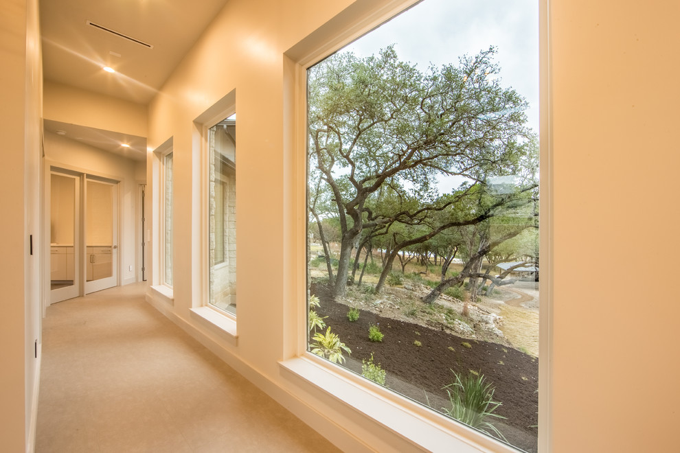 This is an example of a mid-sized contemporary hallway in Austin with white walls and limestone floors.