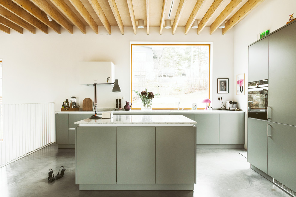 Inspiration for a contemporary l-shaped kitchen in Stockholm with an undermount sink, flat-panel cabinets, green cabinets, stainless steel appliances, concrete floors, with island, grey floor and white benchtop.