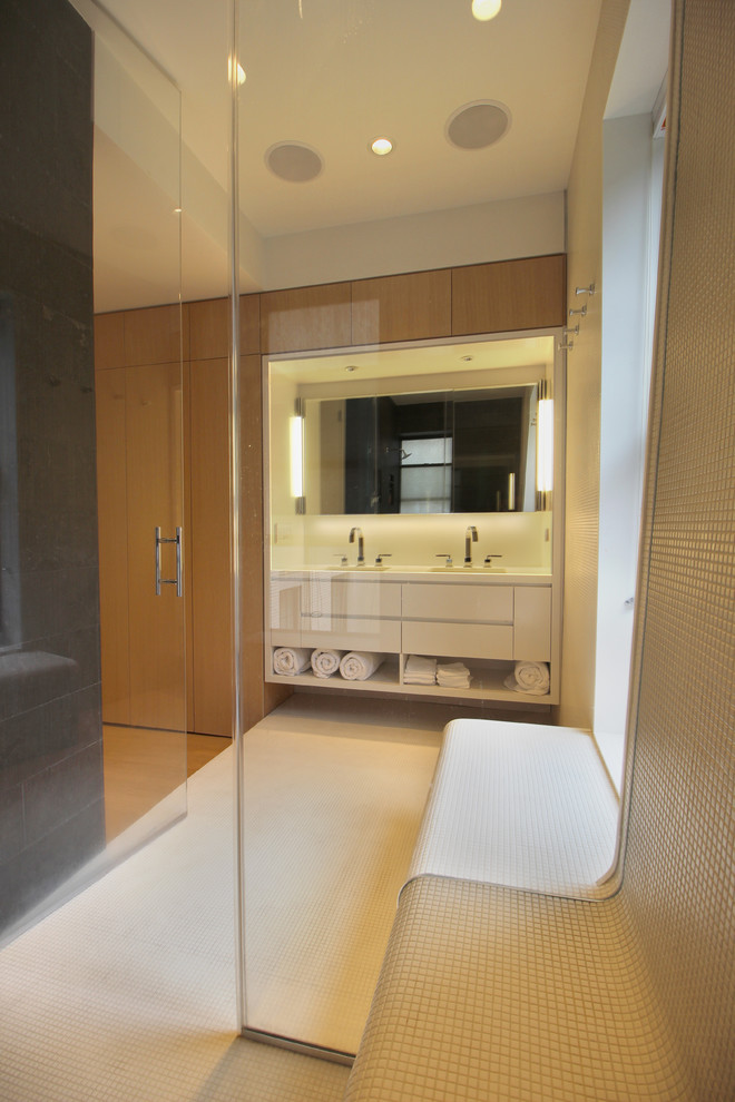 Large modern bathroom in New York with an undermount tub, a shower/bathtub combo, a wall-mount toilet, white tile, white walls, with a sauna, an undermount sink, white floor, a hinged shower door and white benchtops.