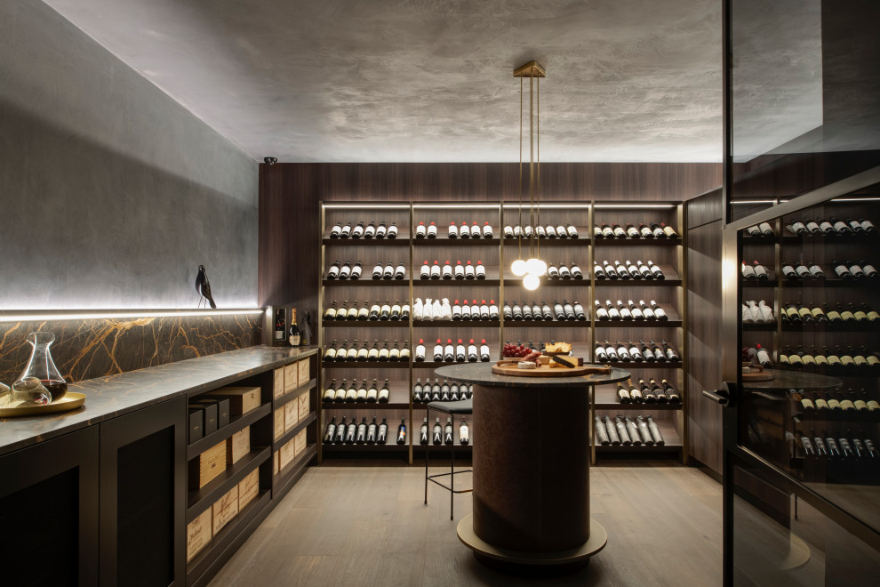 Diseño de bodega contemporánea de tamaño medio con suelo de madera en tonos medios, botelleros y suelo gris