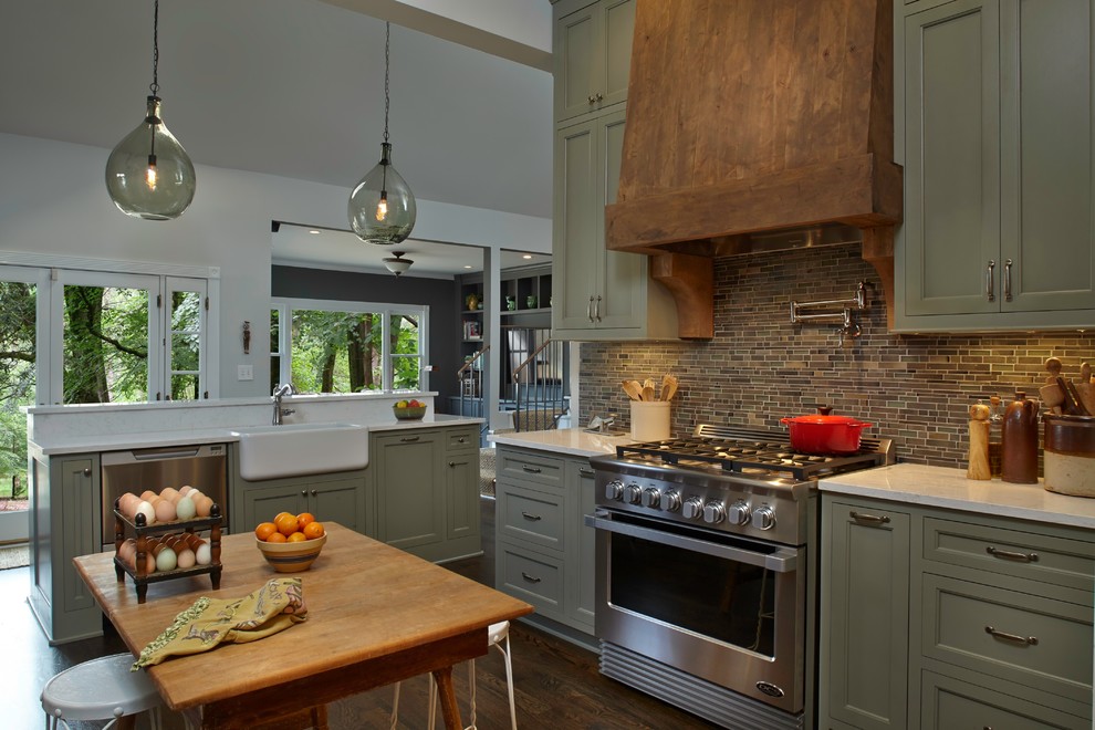 Inspiration for a mid-sized country u-shaped open plan kitchen in Atlanta with a farmhouse sink, shaker cabinets, green cabinets, brown splashback, ceramic splashback, panelled appliances, medium hardwood floors, with island and brown floor.