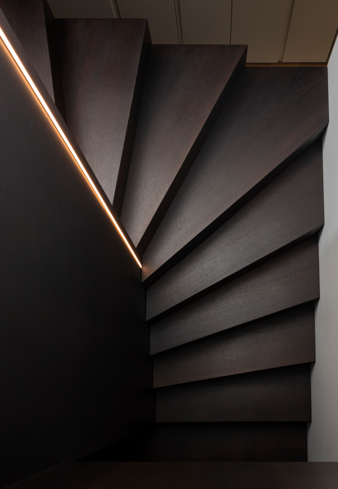 Свежая идея для дизайна: п-образная лестница среднего размера с крашенными деревянными ступенями, крашенными деревянными подступенками, стеклянными перилами и панелями на части стены - отличное фото интерьера