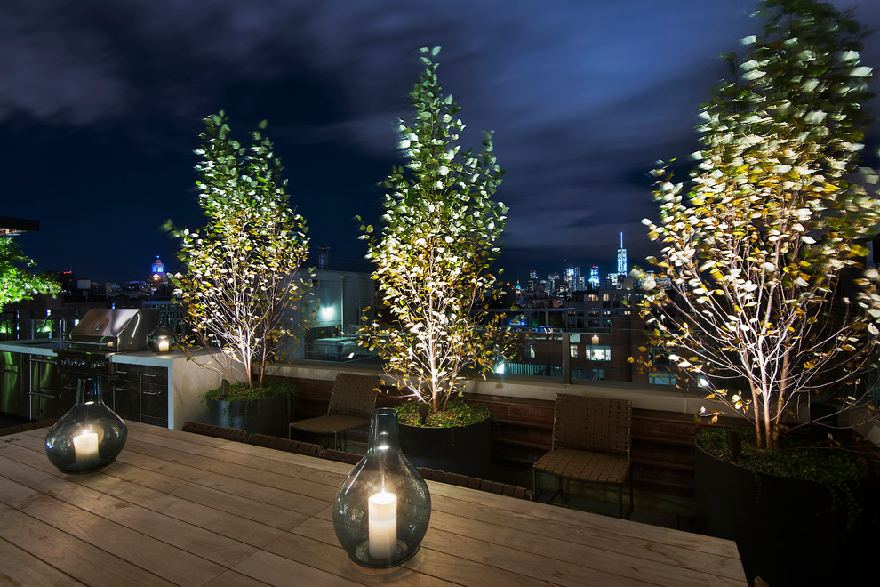 Photo of an expansive contemporary rooftop deck in New York with an outdoor kitchen and a pergola.