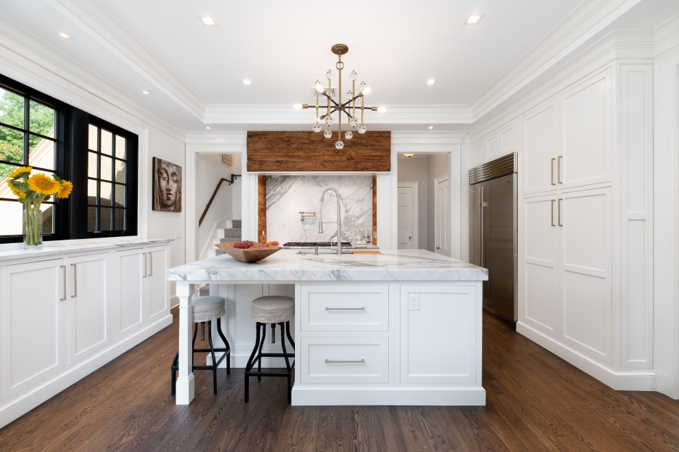 Inspiration for a large transitional kitchen in Bridgeport with an undermount sink, white cabinets, white splashback, stone slab splashback, stainless steel appliances, dark hardwood floors, with island, brown floor, white benchtop and shaker cabinets.