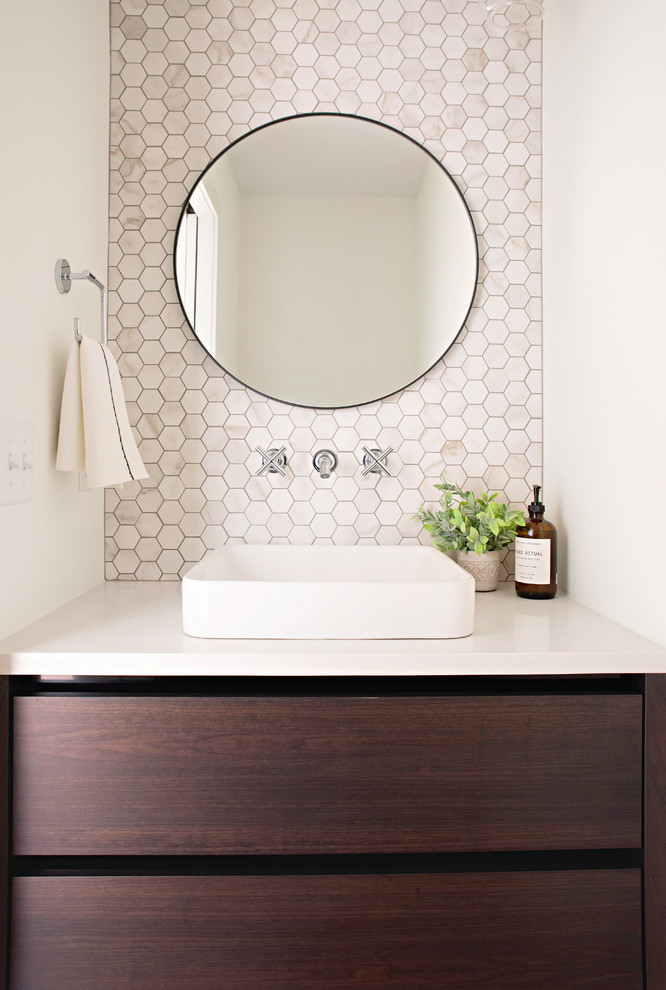 Photo of a small contemporary powder room in Indianapolis with flat-panel cabinets, brown cabinets, a two-piece toilet, beige tile, porcelain tile, white walls, medium hardwood floors, a vessel sink, engineered quartz benchtops, brown floor and white benchtops.