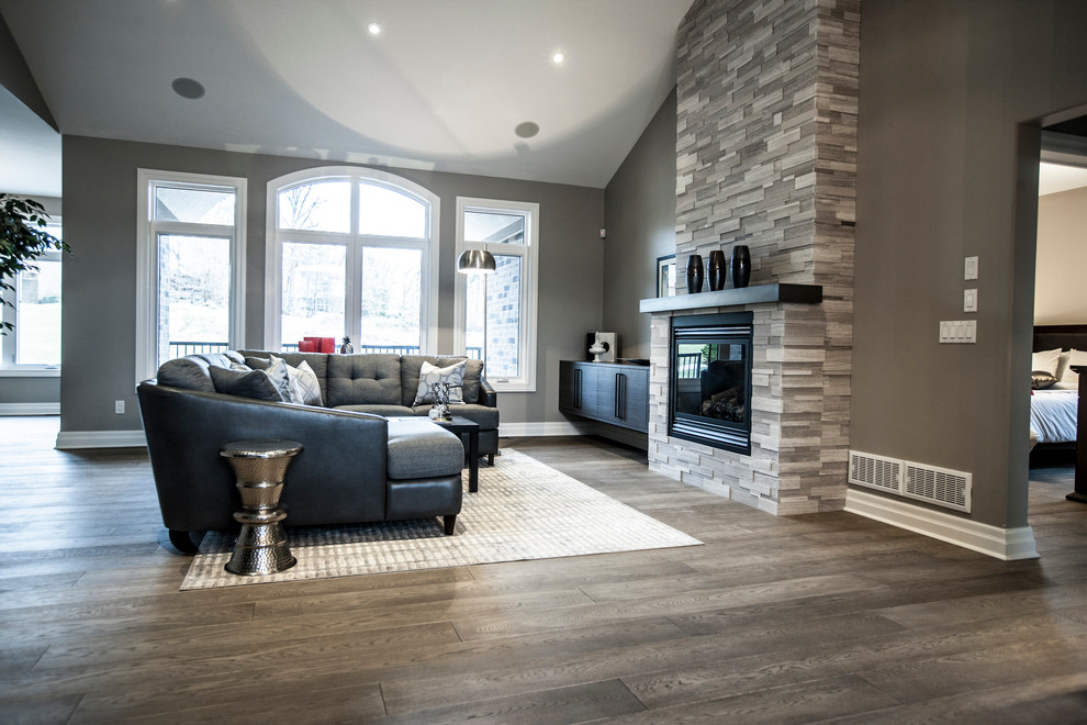 Inspiration for a mid-sized contemporary open concept living room in Toronto with grey walls, light hardwood floors, a standard fireplace and a stone fireplace surround.