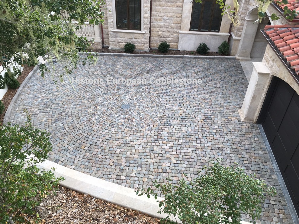 This is an example of a large traditional courtyard shaded driveway in San Francisco with natural stone pavers.