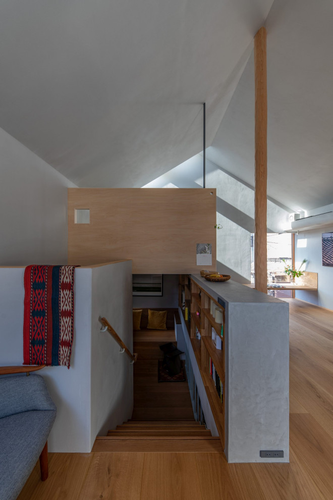 Kleines, Offenes Skandinavisches Wohnzimmer ohne Kamin mit grauer Wandfarbe, Sperrholzboden, TV-Wand und braunem Boden in Tokio
