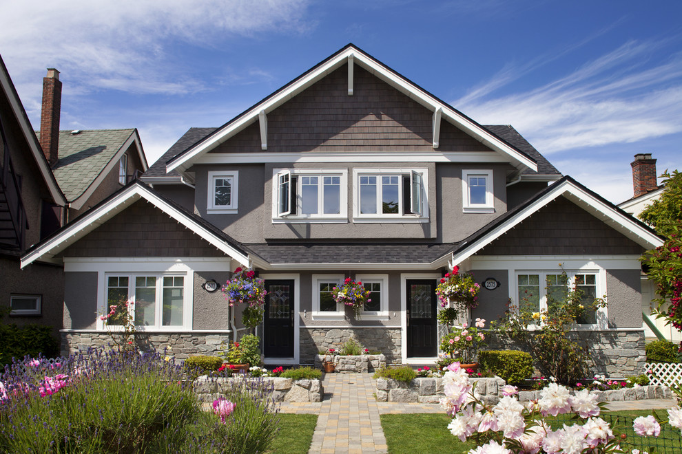 Design ideas for a mid-sized traditional two-storey stucco grey duplex exterior in Vancouver with a gable roof.
